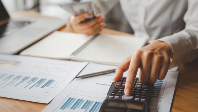 Business women counting money, saving money and calculating with a calculator Saving for the future
