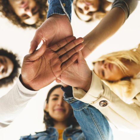 Diverse people stacking hands together