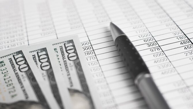 Money, accounting documents invoices and a pen. Close-up, low angle view, selective focus