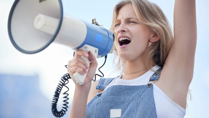 Woman protest leader, megaphone in hand and speech support for human rights, freedom and ending rac